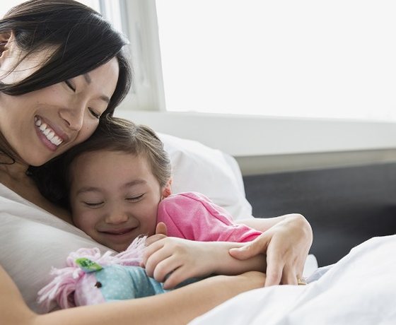 A mother hugging her smiling daughter